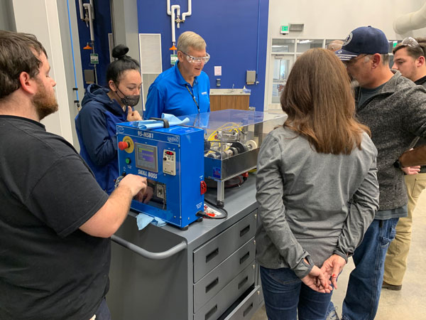 Students watching demonstration for a skill boss machine