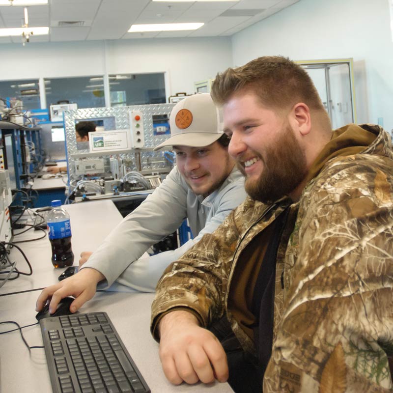 Two students working in the lab at a computer