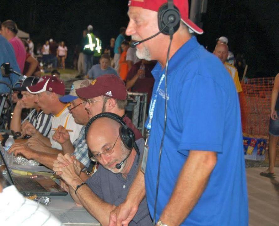 Jay Coomes standing at announcers desk