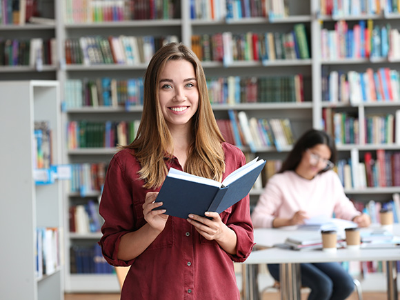 Female reading a book in the library. 