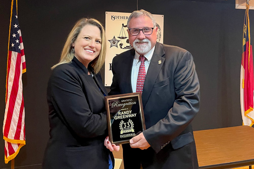 President Margaret Annunziata presents an award of special recognition to Randy Greenway, a distinguished law enforcement professional who is retiring as an Isothermal BLET instructor after teaching since the late 1980s.