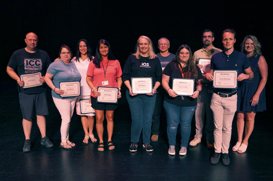 All award winners standing with certificates on stage