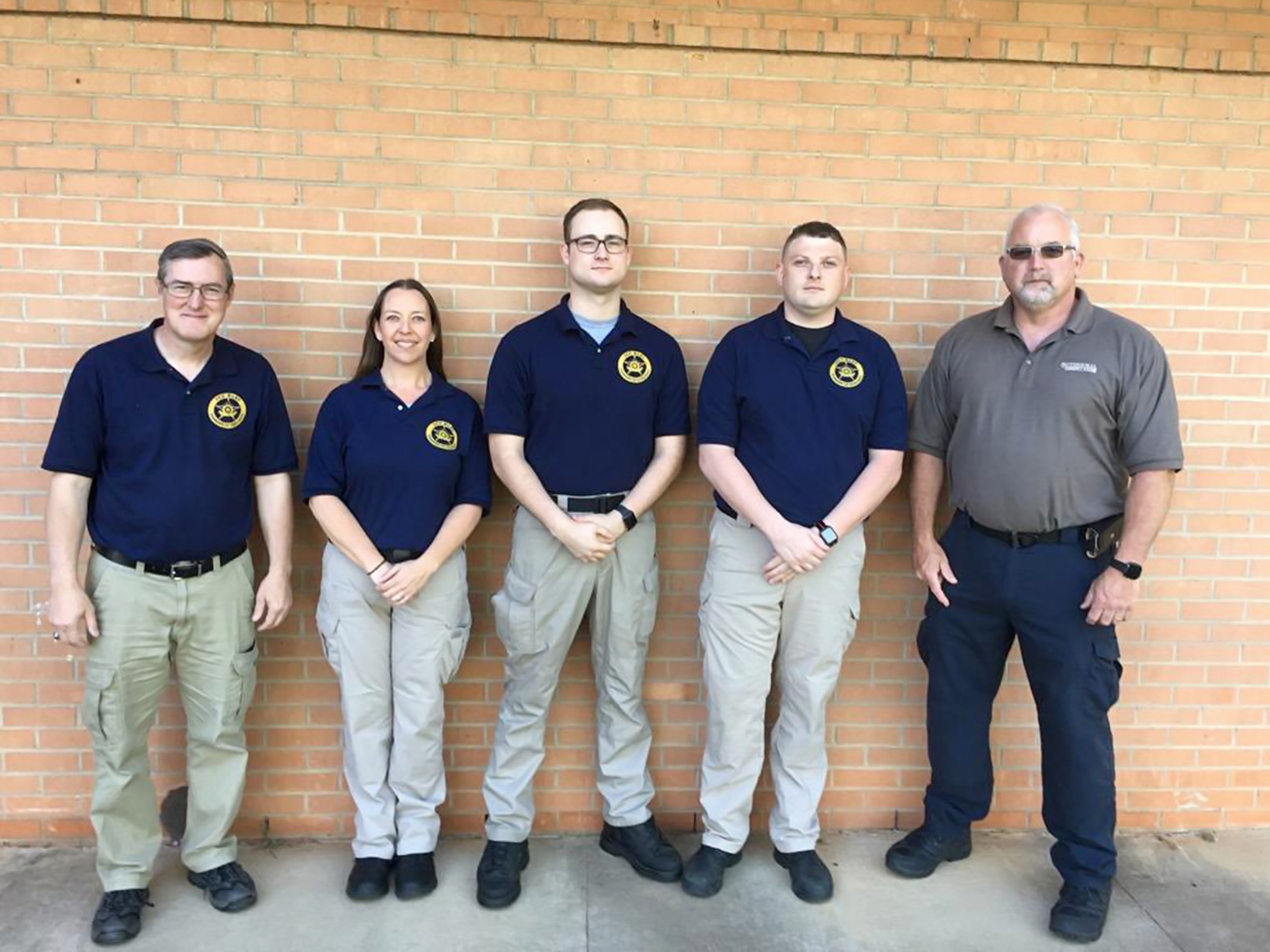 Four graduates with Instructor lined up Four graduates with Instructor lined up