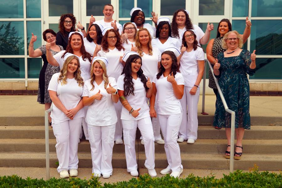 Group of all graduates in uniform on steps of the Foundation Performing arts center