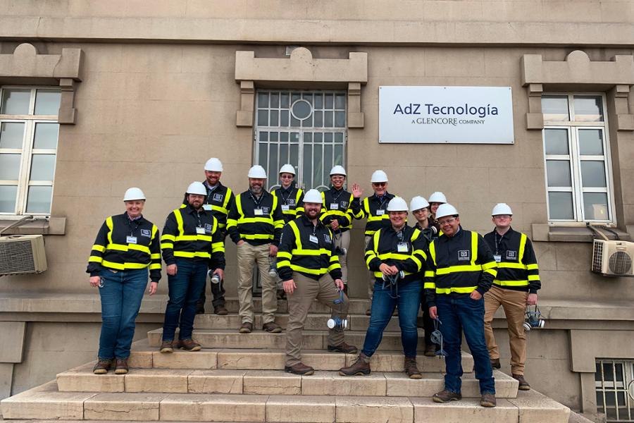 12 trip participants standing behind large letter sign for Asturias company