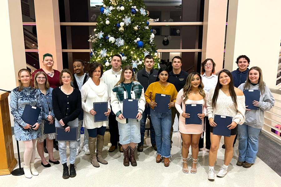 18 award recipients with their certificates in the Foundation Lobby