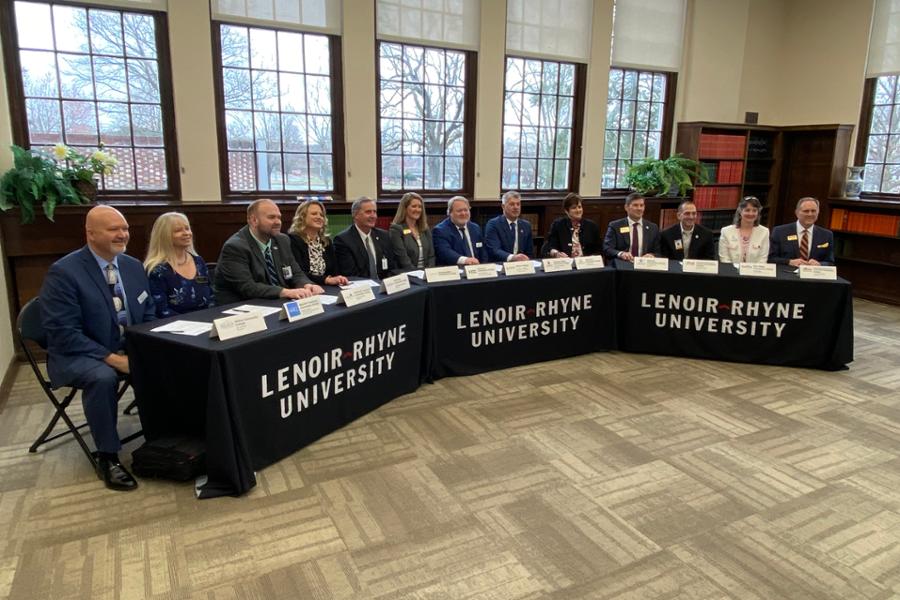 All representatives from local community colleges at panel tables for the signing