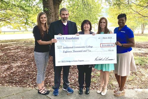 SECU representatives with ICC leaders holding oversized check