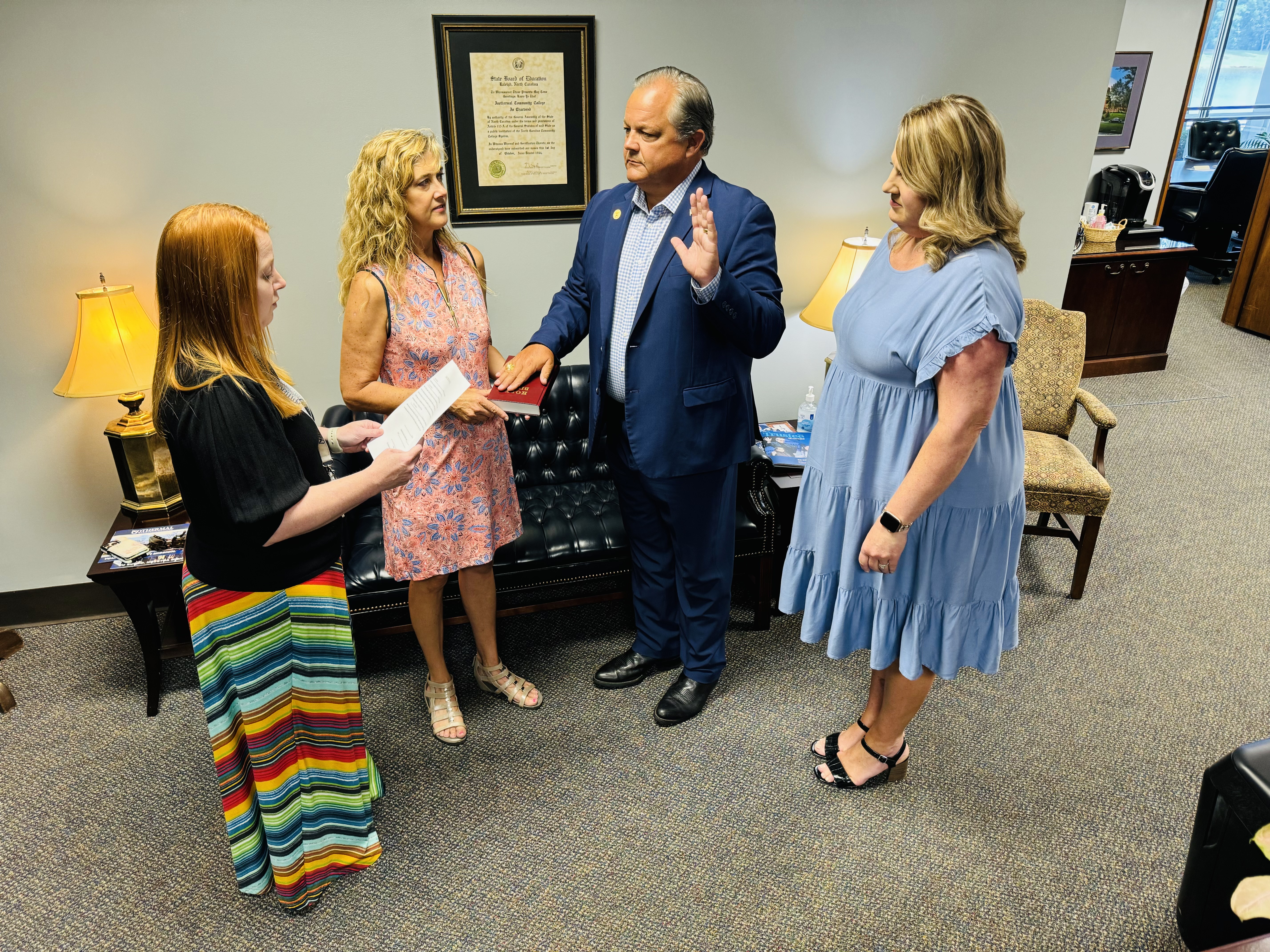 Tony Helton is pictured with his hand on a bible being sworn in as a new member of the Isothermal Community College Board of Trustees.