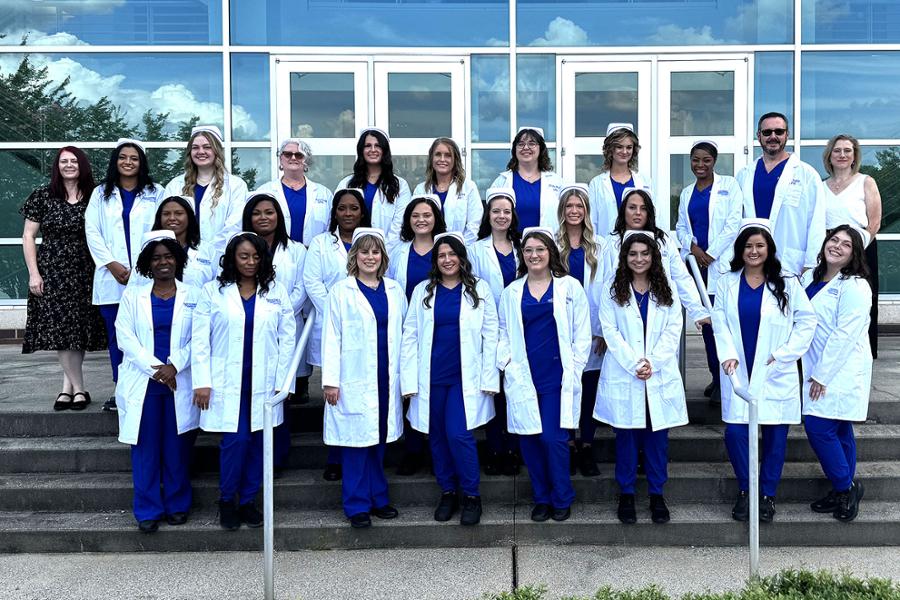 PN Pinning group photo of graduates wearing white coats