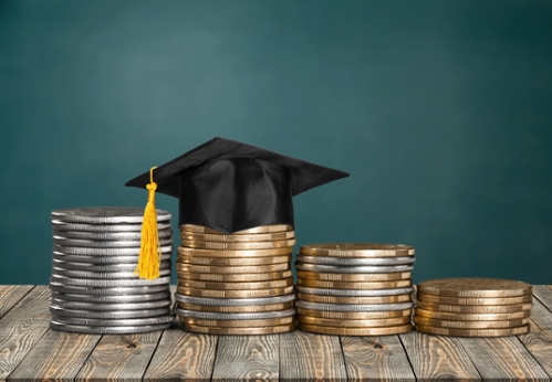 Stacks of coins with a mortar cap and tassel on top Stacks of coins with a mortar cap and tassel on top
